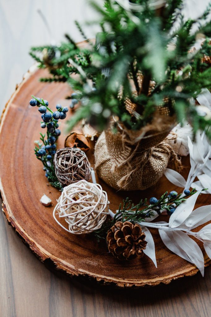 Neutral colors with winter holiday board centerpiece, pine cone, decorative small tree, blueberries