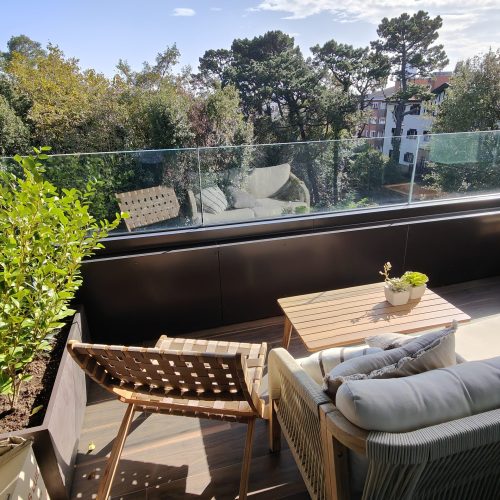 Terraza moderna con mobiliario acogedor y vistas naturales, creando una transición fluida entre el interior y el exterior.